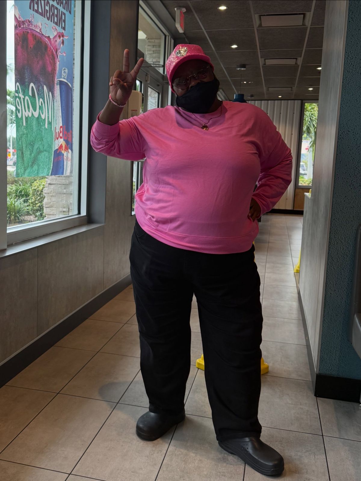 Team member in pink giving a peace sign