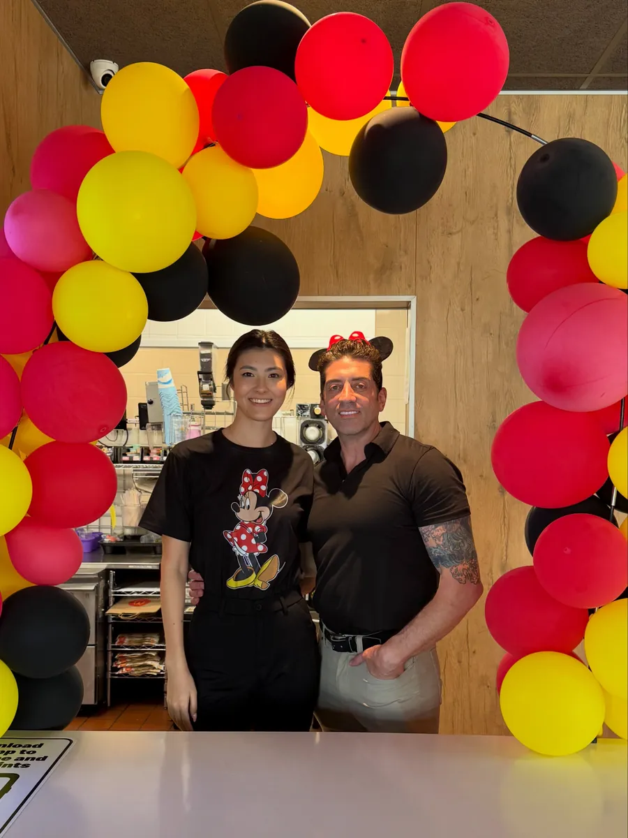 Crew members in front of a red and yellow balloon arch during People Week