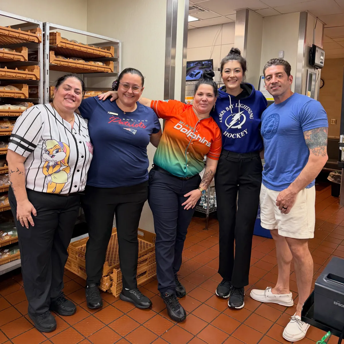Crew in sports jerseys near the bakery shelves