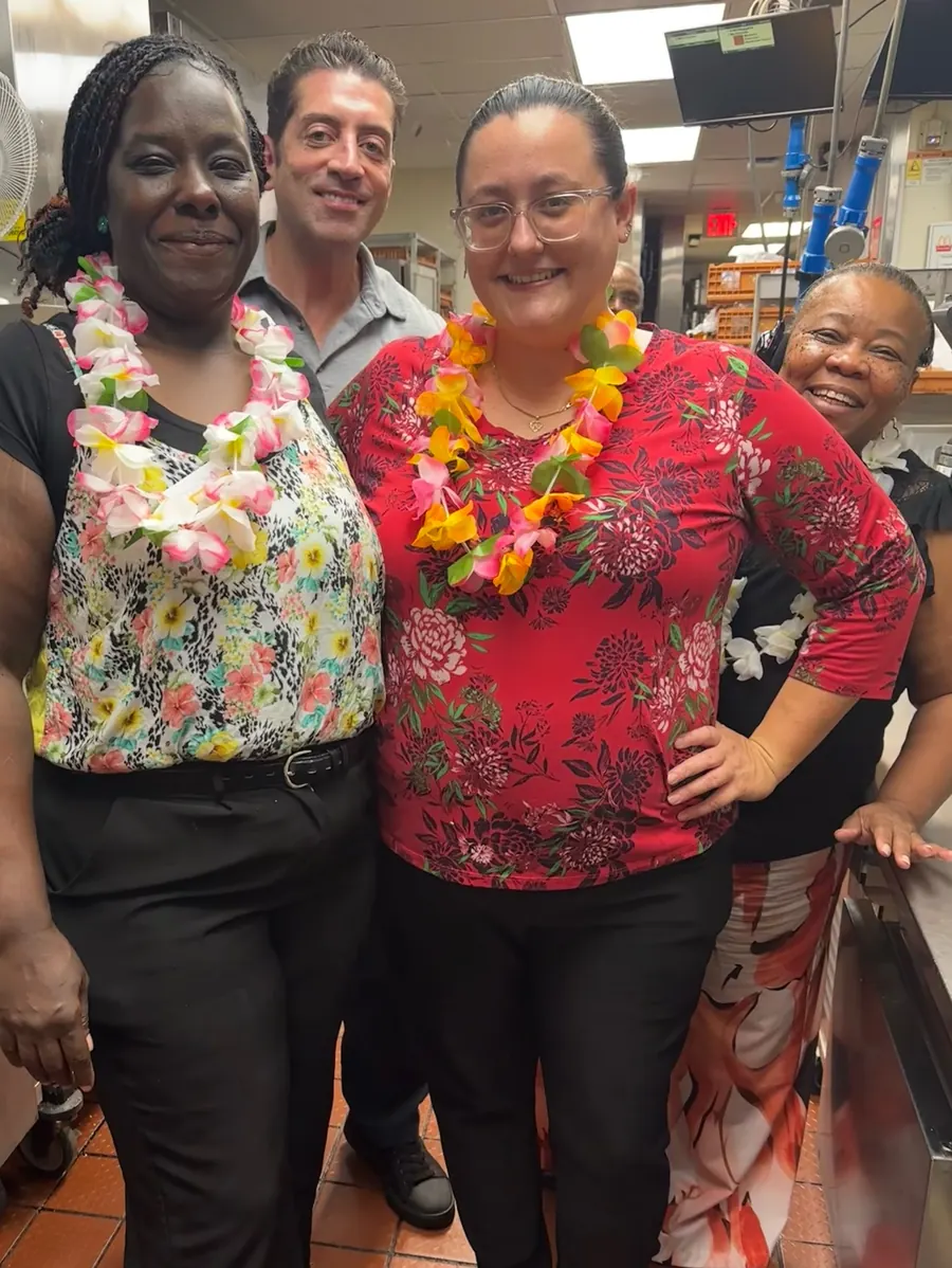 Two crew members in Hawaiian shirts and leis for Maui Monday
