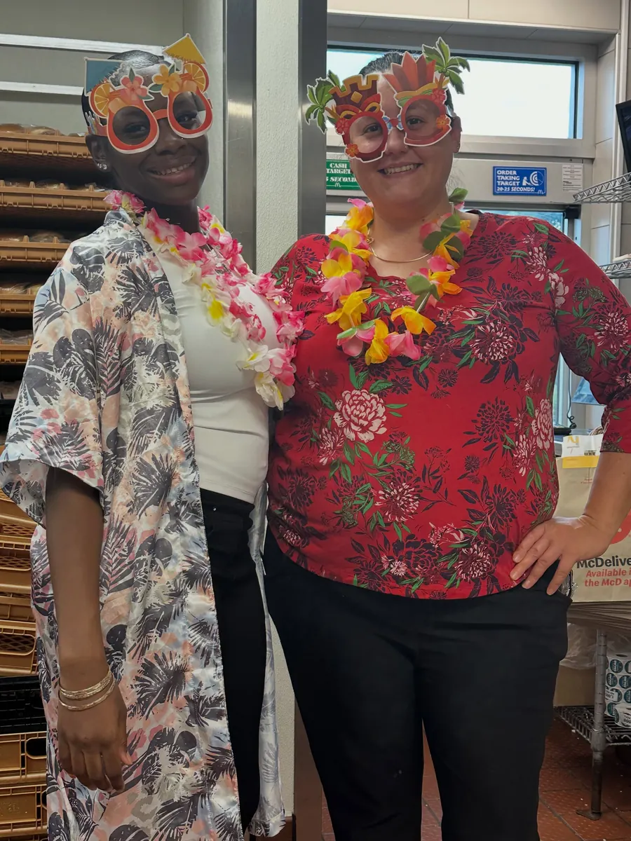 Two team members in floral shirts and leis for Maui Monday