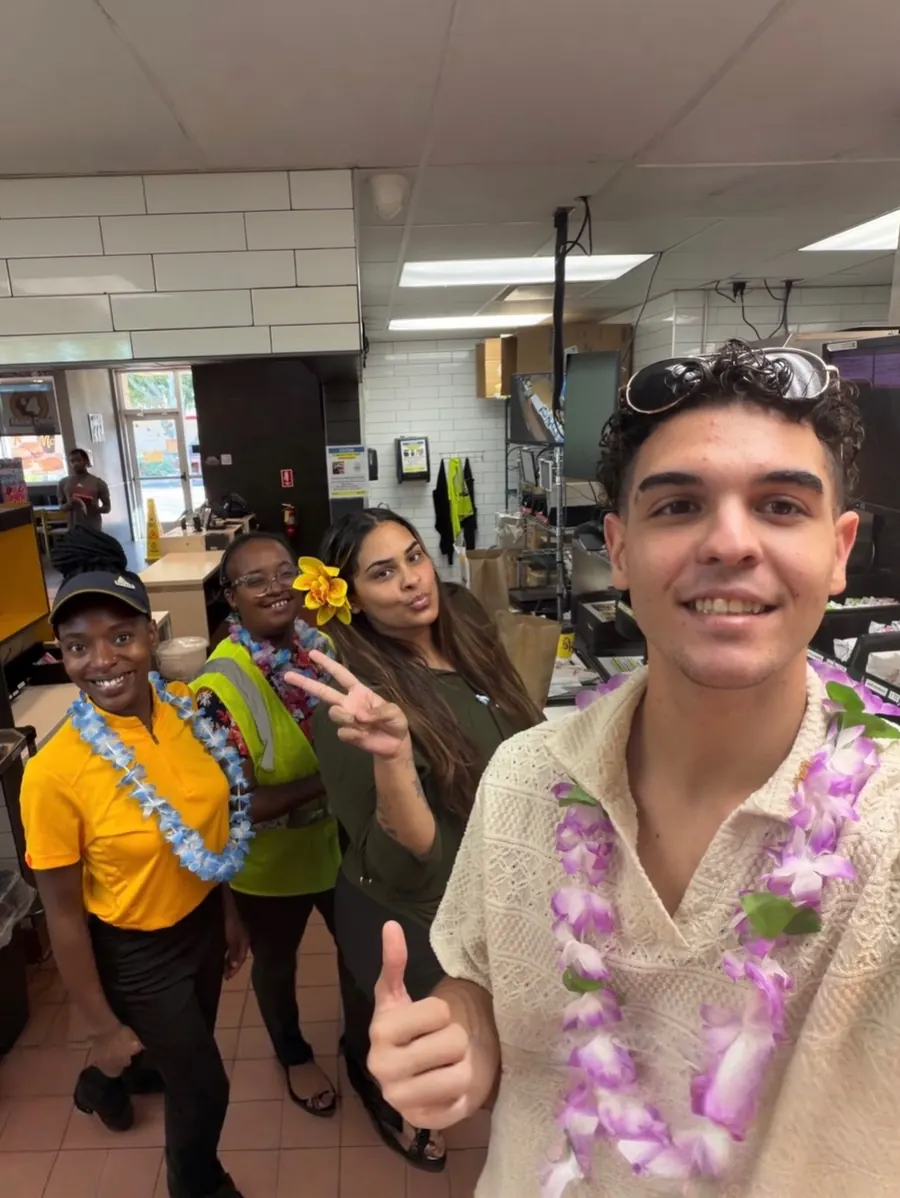 Young crew member in a lei giving a thumbs-up for Maui Monday