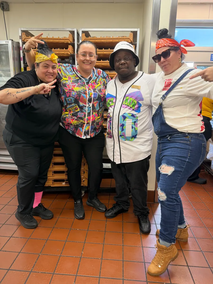 Crew in colorful retro shirts and hats near the bakery racks
