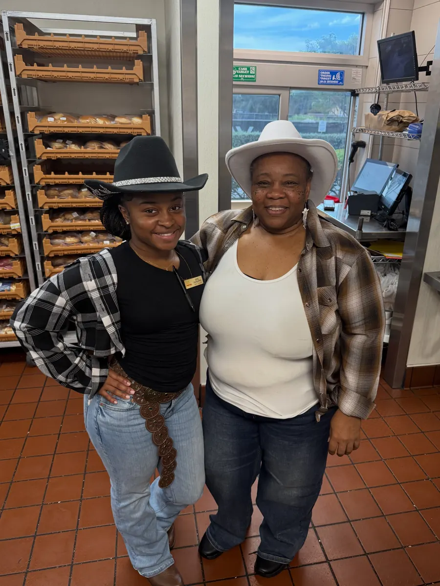 Two crew members in cowboy hats and plaid shirts
